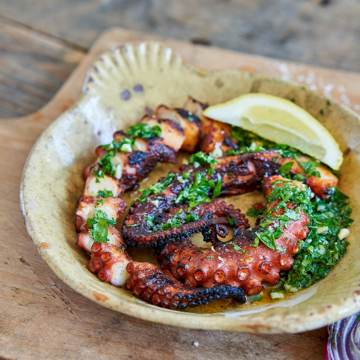 Cooked octopus in a bowl with lemon