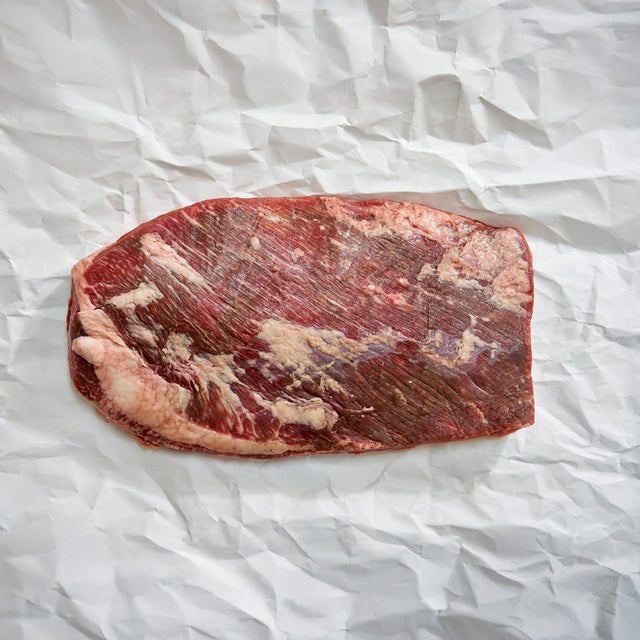 Raw beef brisket on crumpled white paper