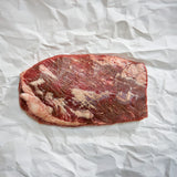 Raw beef brisket on crumpled white paper