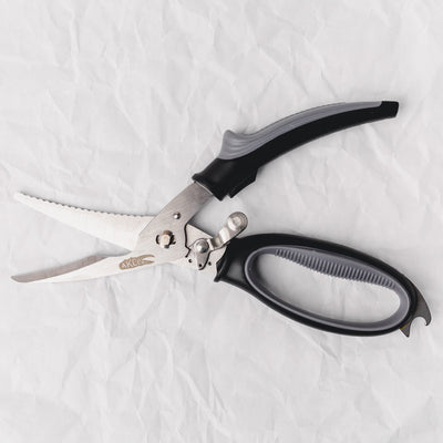 Pair of kitchen shears with black handles on a white fabric background