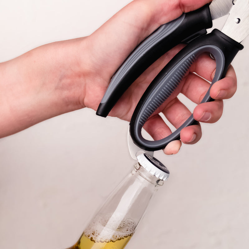 Person using a bottle opener on a bottle with a white background