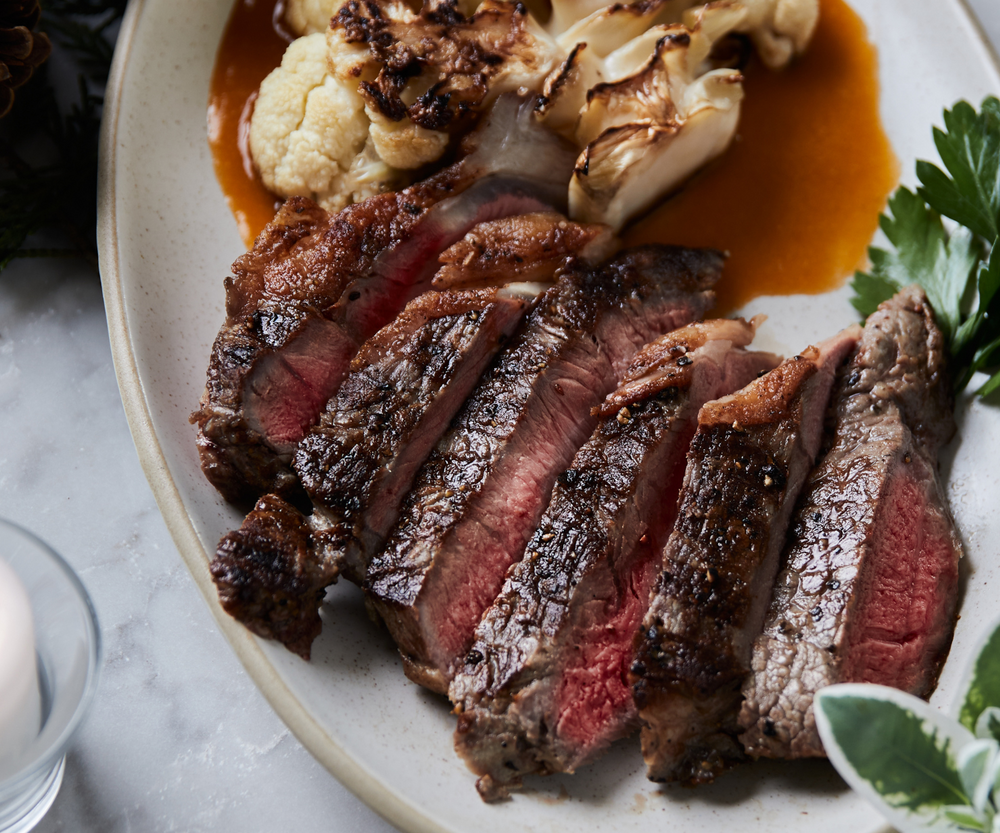 Sliced steak with roasted cauliflower on a plate