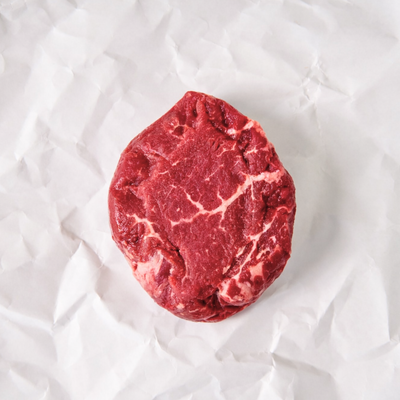 Raw steak on a white textured surface