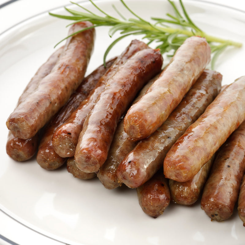 Assorted sausages on a white plate with rosemary garnish