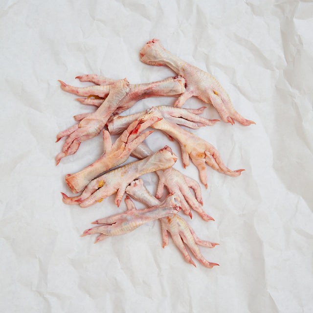 Raw chicken feet on a white butcher paper