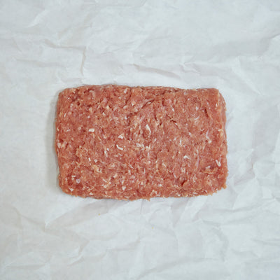 Block of ground chicken on a white paper background