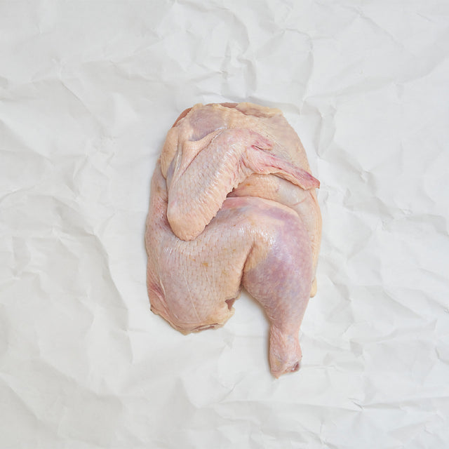 raw half chicken on butcher paper