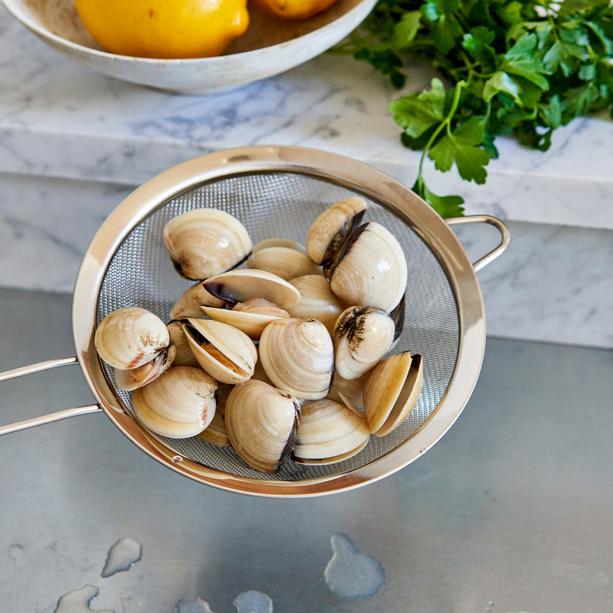 Hardshell clams in a strainer 