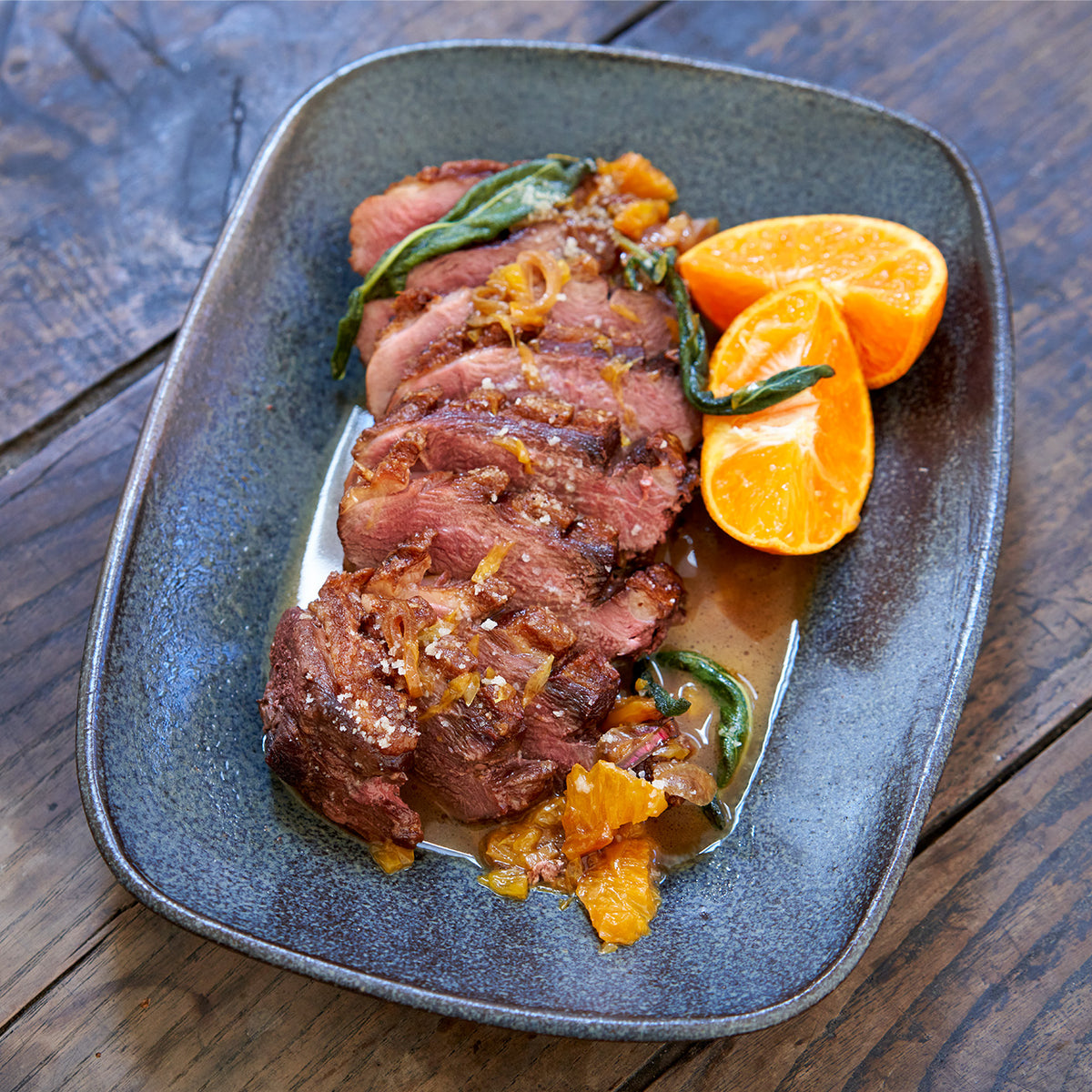 Sliced cooked Moulard duck breast with orange slices 