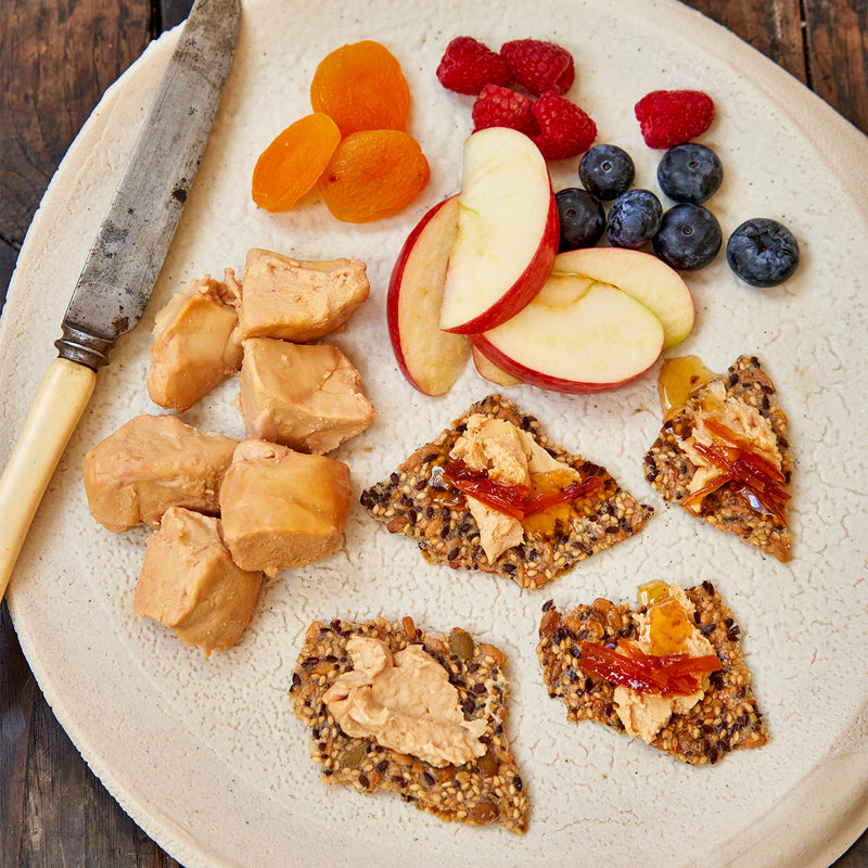 Moulard duck fois grois on sesame seed crackers with a side of fruit 
