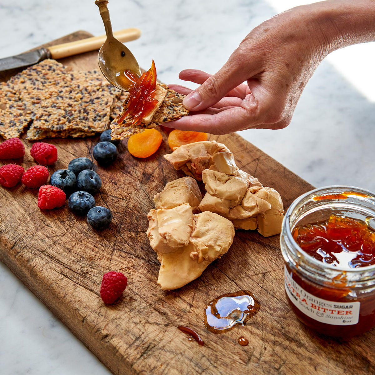 Moulard duck fois grois on sesame seed crackers with a side of fruit 