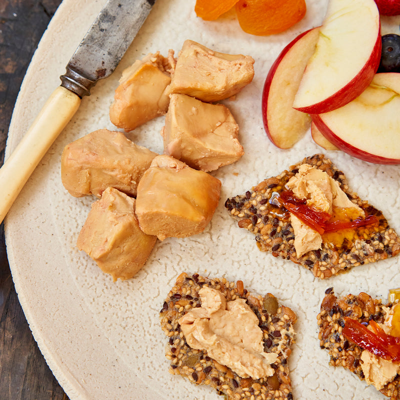 Moulard duck fois grois on sesame seed crackers with a side of fruit 