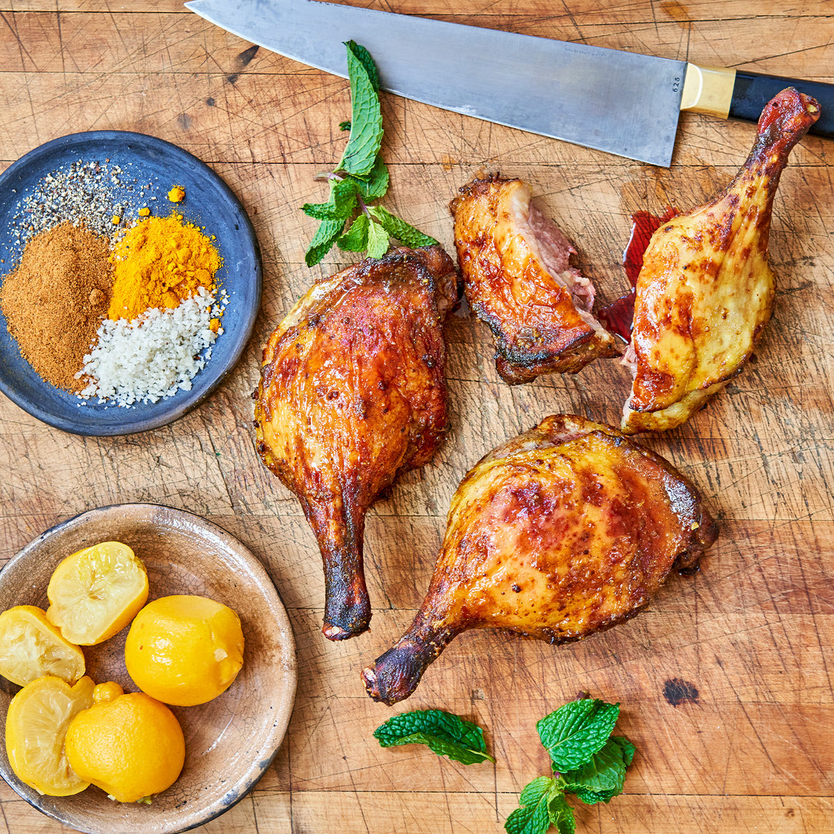 Cooked Moulard deck leg quarters on a chopping block 