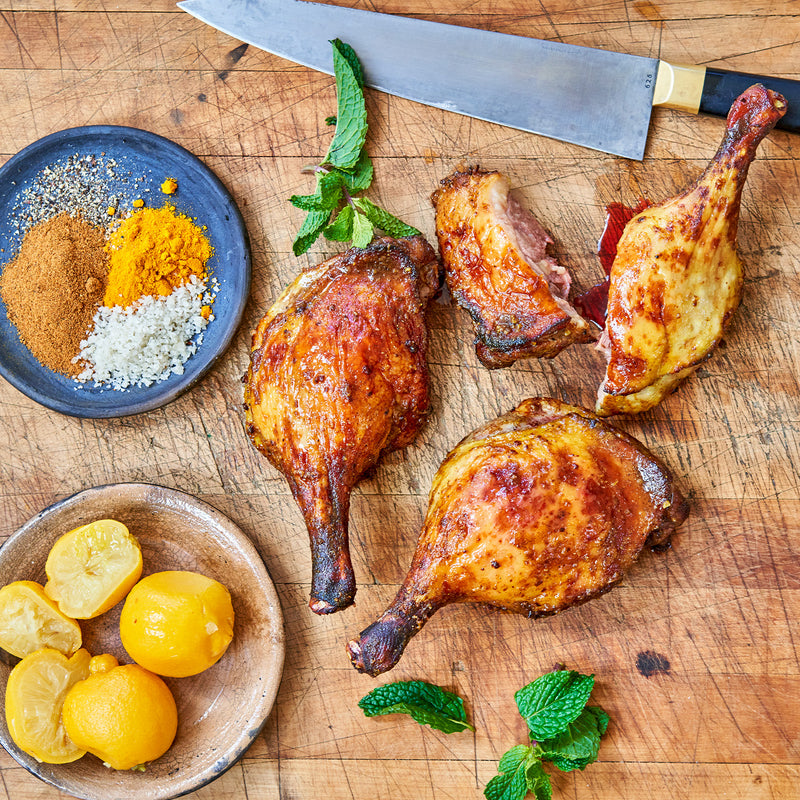 Cooked Moulard deck leg quarters on a chopping block 