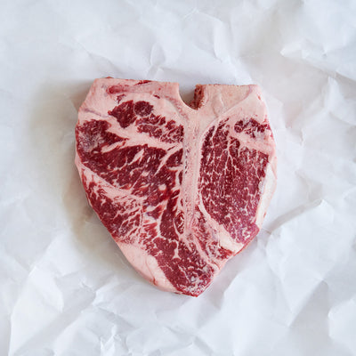 Marbled raw porterhouse steak on a white background
