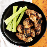 Plated chicken wings with a side of celery