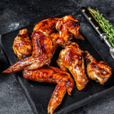 Plated chicken wings with BBQ sauce on top of the wings