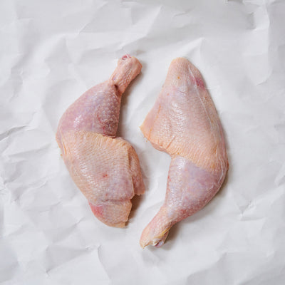 Raw whole chicken legs on butcher paper 