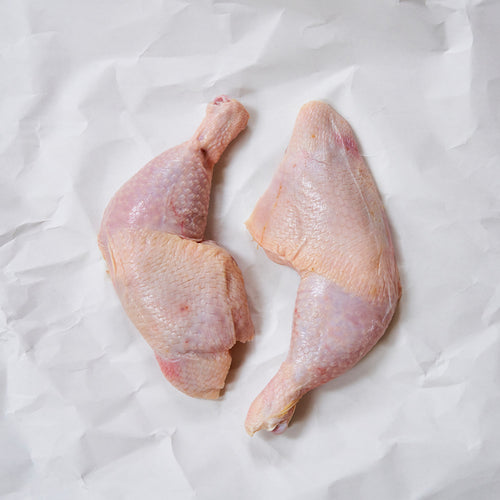 Raw whole chicken legs on butcher paper 