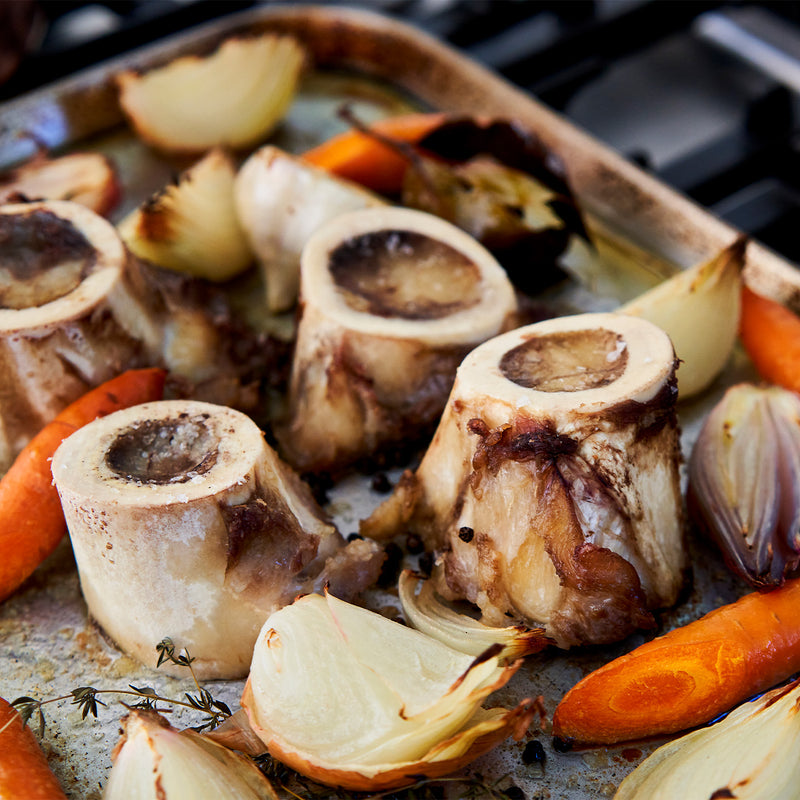 Roasted bones with vegetables on a baking tray