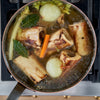 Center Cut Marrow Bones cooking in broth with vegetables - Market House