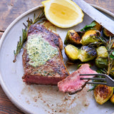 Steak with lemon and brussels sprouts on a plate